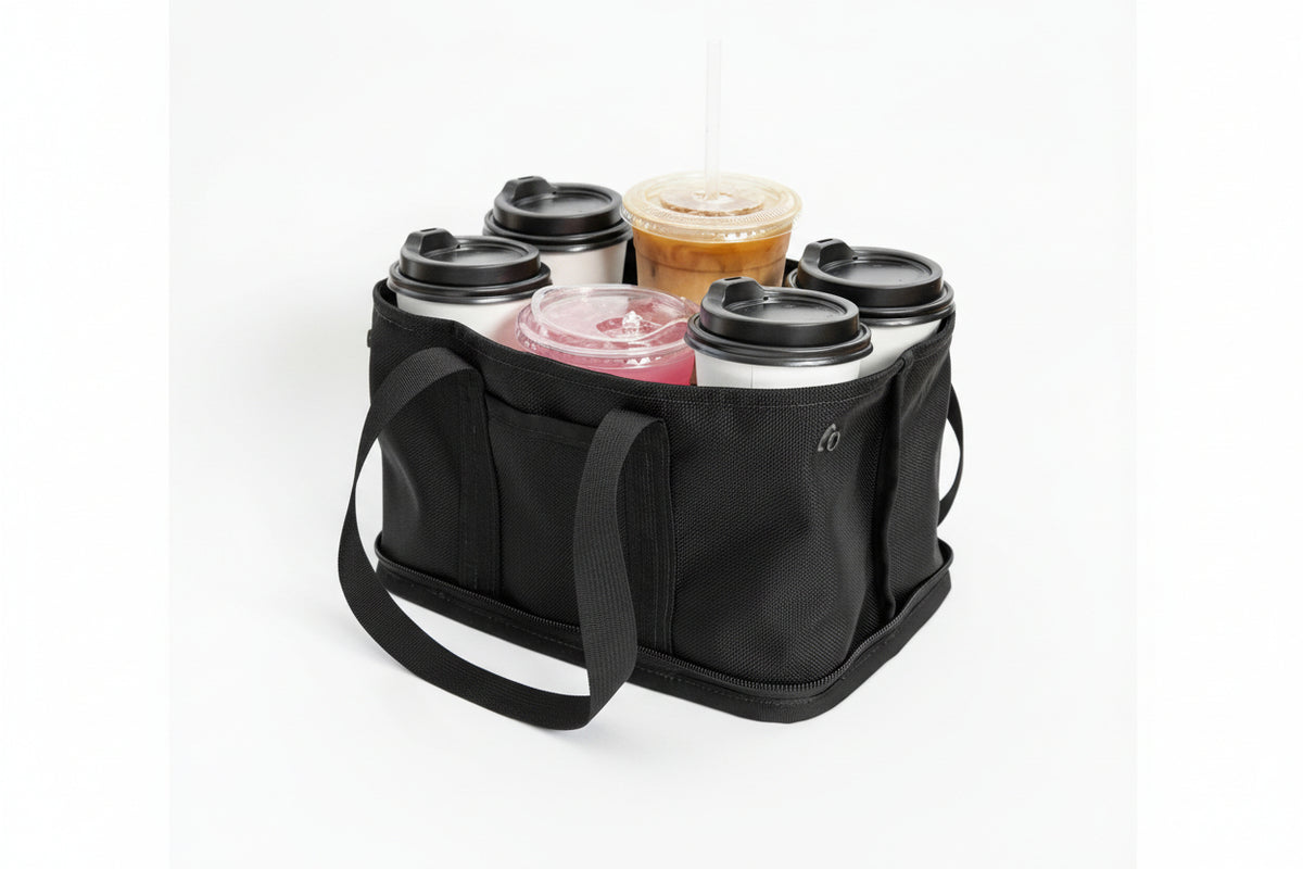 A black reusable coffee tote bag with six handles, shown holding six drinks in travel cups on a clean white background.