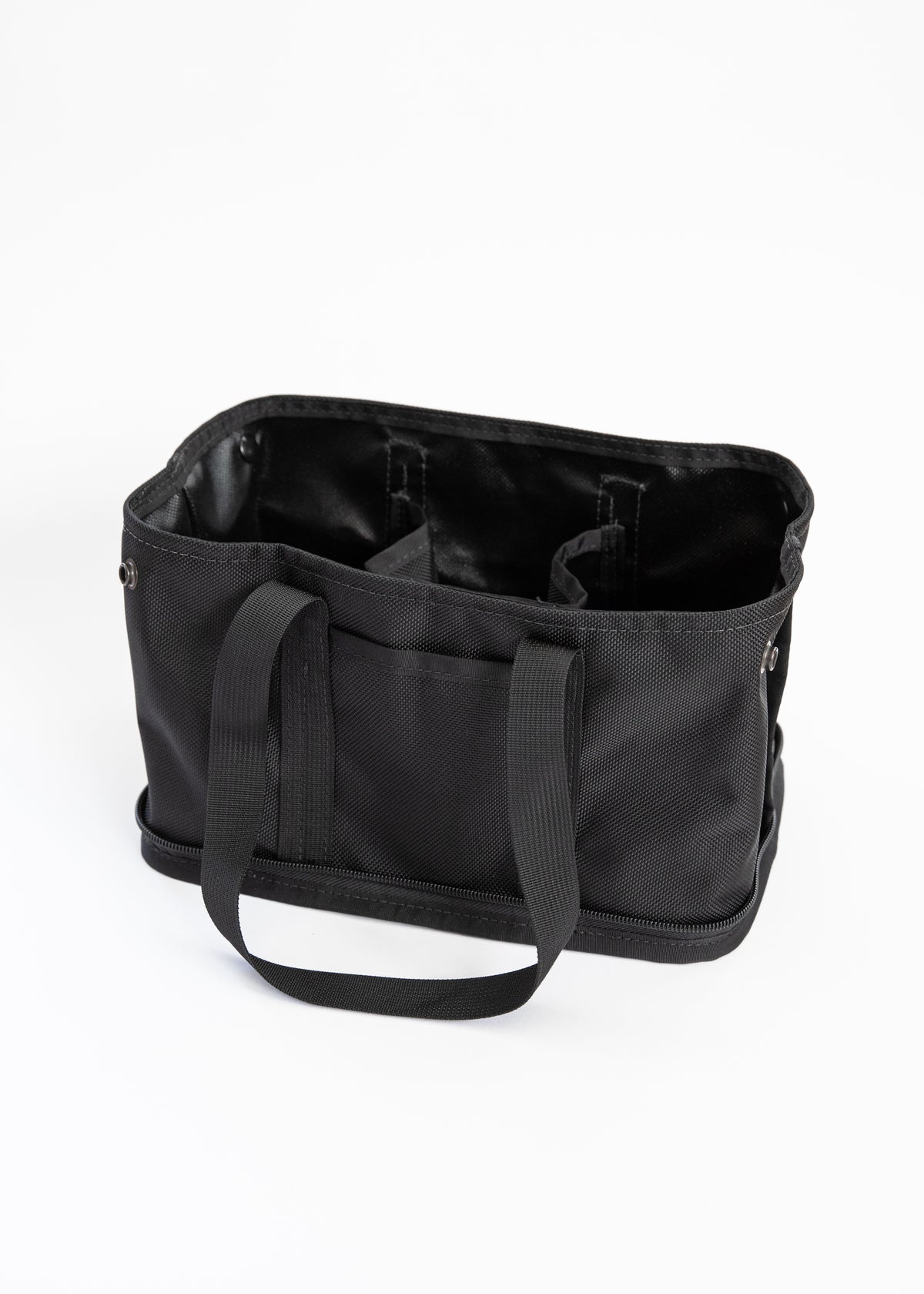 A black fabric tote bag with dual shoulder straps, shown from a three-quarters angle to display its interior compartments and lining on a white background.